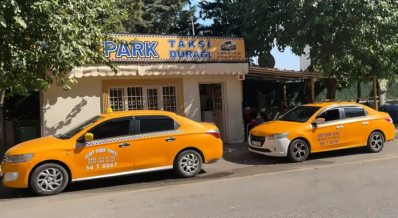 Siirt Park Taksi Durağı binası, yanındaki gölgelikli bekleme yeri ve önünde iki sarı taksi